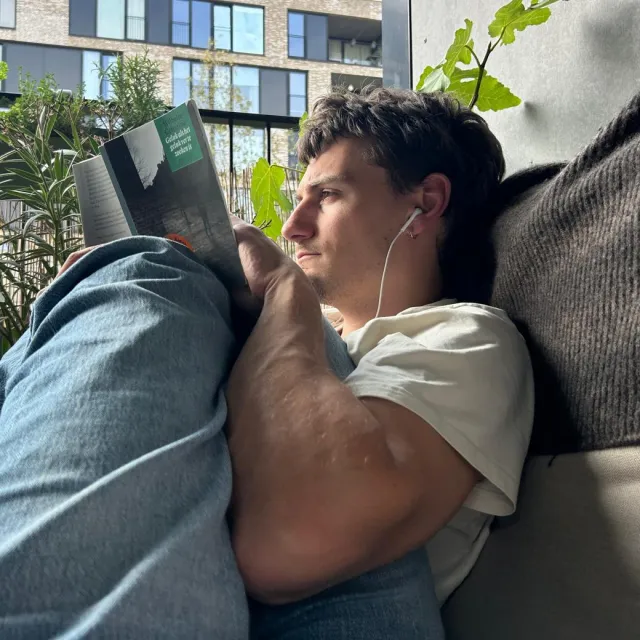 Harm leest een boek op zijn balkon